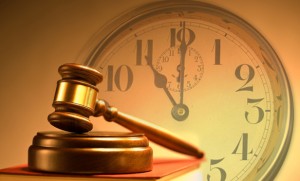 Vintage style wooden gavel from the court placed on a stack of law books on background